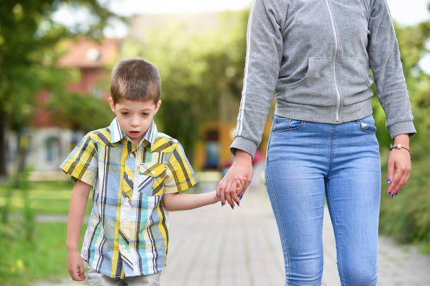 istock mother, father and son holding hands in park 1028972462