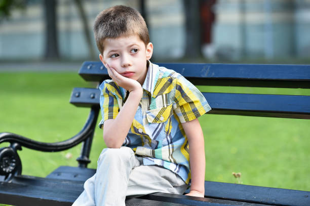 istock sad child boy sitting on a bench 1028974770