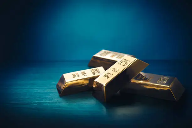 Photo of Pile of gold bars or ingots on a dark background