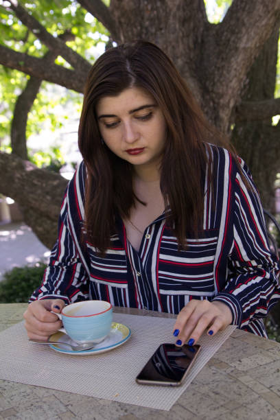 夏、公園、ビジネス スタイルで街のストリート カフェのテーブルでコーヒーを飲む若いビジネス女性の公園でプラスのサイズの女性 - gaining weight audio ストックフォトと画像