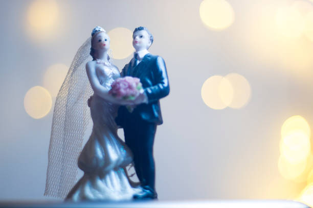 istock Wedding ceremony marriage bride groom cake topper figures with lights isolated. 1028975458