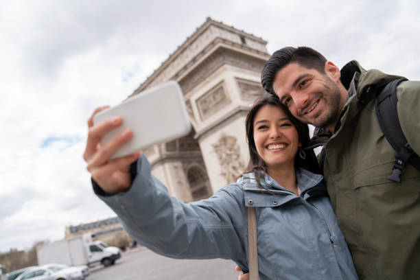 istock Happy couple sightseeing in Paris and taking a selfie 1028983520