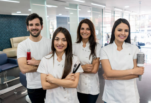 zuversichtlich team von friseuren in einem friseursalon, blick in die kamera lächelnd mit arme gekreuzt - beauty spa scissors hairstyle beautician stock-fotos und bilder