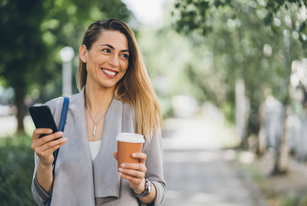 istock Happy woman walking and texting 1029013604