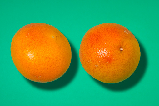 Two Grapefruits on Green colored background