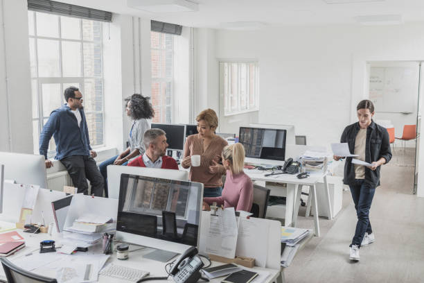 istock Busy office interior with business people chatting and working 1029044448