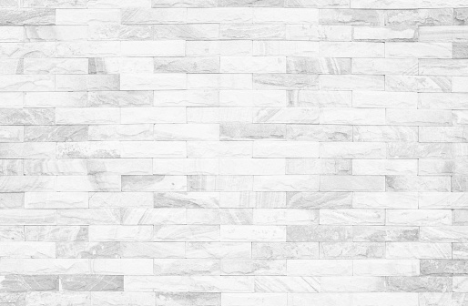 Grey and White brick wall texture background. Brickwork or stonework flooring interior rock old pattern clean concrete grid uneven bricks design stack.