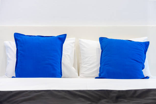 istock Two white pillows and blue cushions on bed in a bedroom. 1029079518