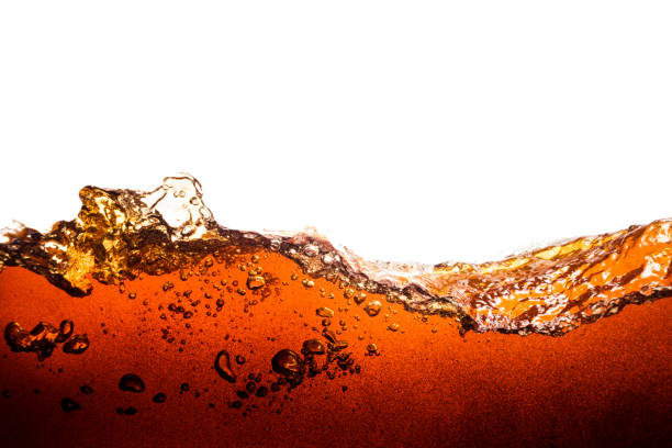 Background of refreshing cola flavored soda with bubbles Side view background of refreshing cola flavored soda with bubbles isolated on white cola photos stock pictures, royalty-free photos & images