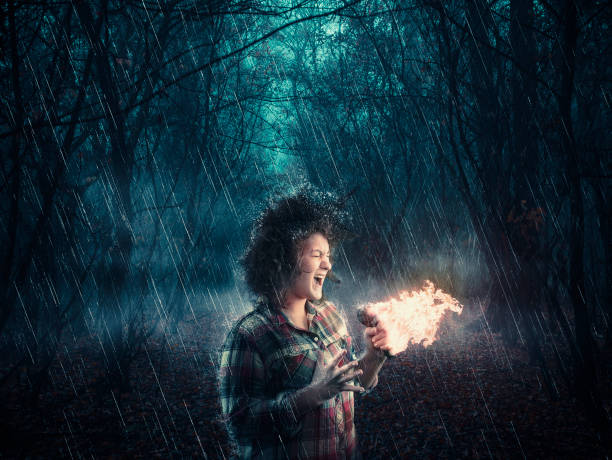 istock Woman in the woods sings on microphone and makes it burns while raining. 1029128308