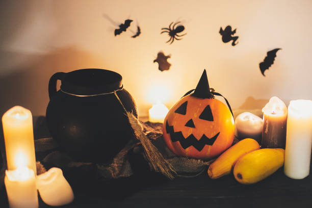 istock Happy Halloween. Jack o lantern pumpkin with candles, bowl, witch broom and bats, ghosts on background in dark spooky room. fall halloween image. spooky atmospheric moment 1029141012
