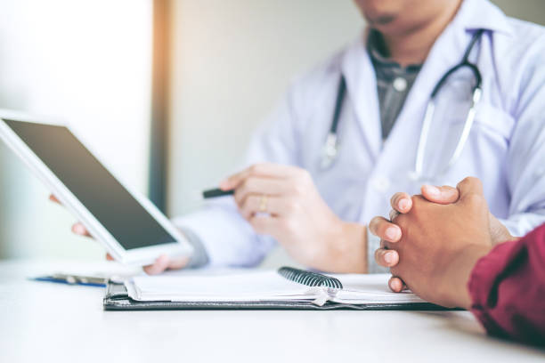istock Doctor consulting with patient presenting results on digital tablet tablet sitting at table 1029146966