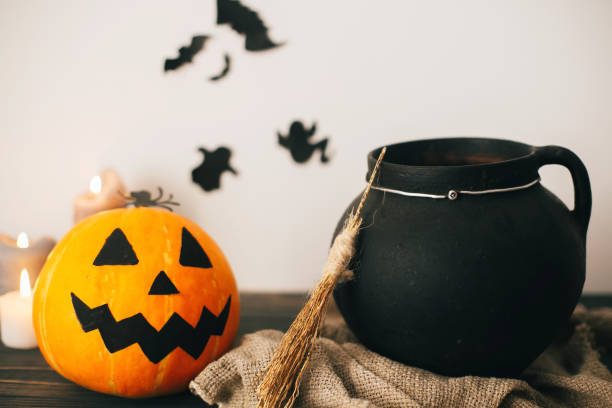 istock jack o lantern pumpkin with candles, bowl, witch broom and bats, ghosts on background in spooky room. Happy Halloween concept. fall halloween image. 1029147218