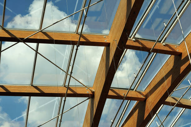 cloudy blue sky seen through transparent roof constructed with beams of glued laminated timber