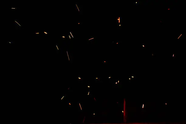 Photo of bonfire spark in the dark sky in night, shallow focus