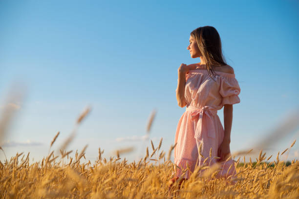 istock Woman in wheat field at sunset 1029167462