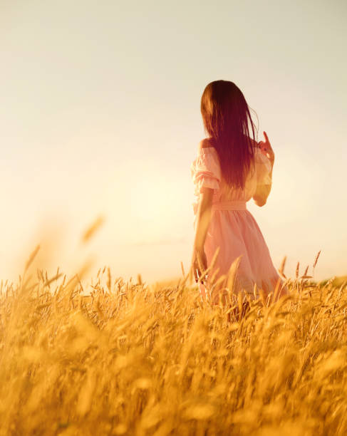 istock Woman in wheat field at sunset 1029167984