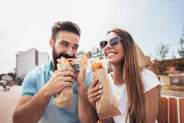 Young couple is eating sandwiches and having a great time