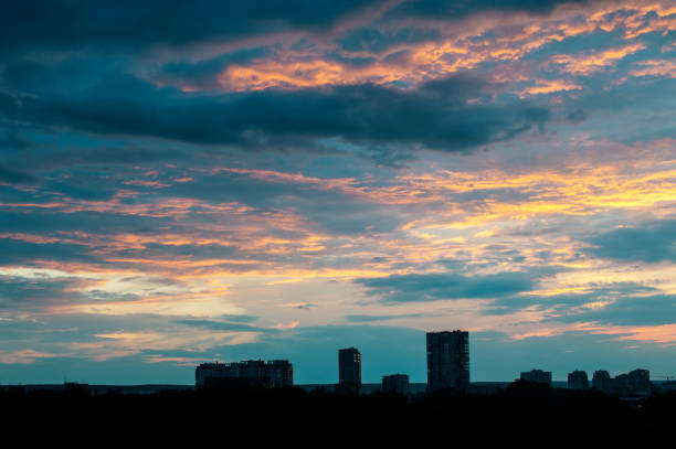 Colorful sunset with blue and orange clouds over the city stock photo