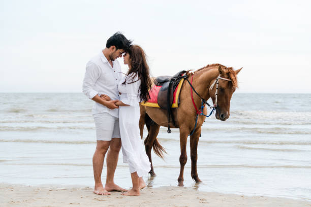 istock Young couple goes horse riding on tropical beach. 1029172946