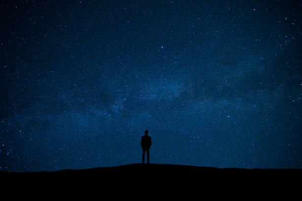 istock The man standing on the starry sky background 1029173520