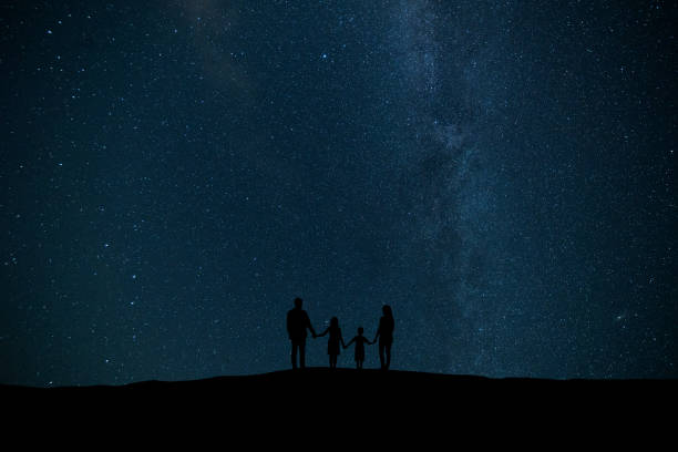 The family standing on the background of a sky with stars stock photo