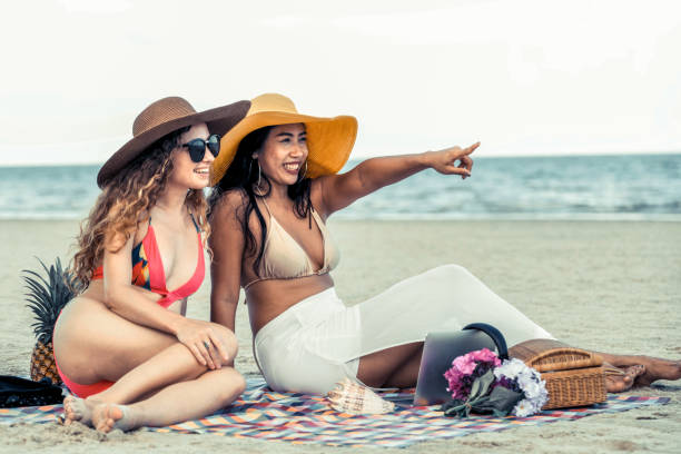 istock Happy women sitting on sand beach in summer. 1029173552