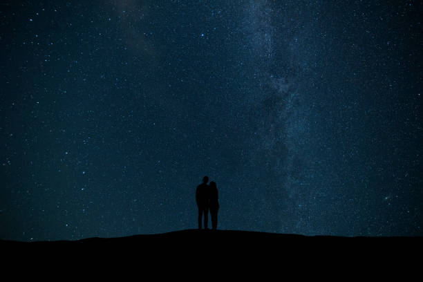 istock The couple standing on the starry sky background 1029173576