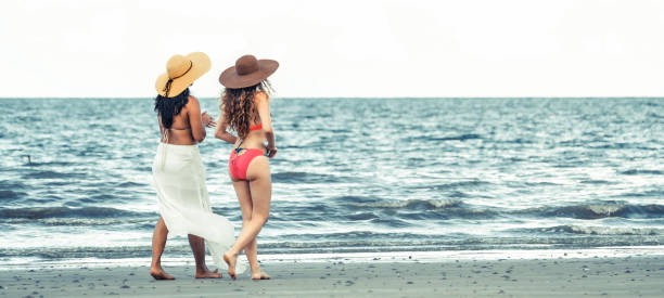 istock Happy women go sunbathing at sand beach in summer. 1029173694