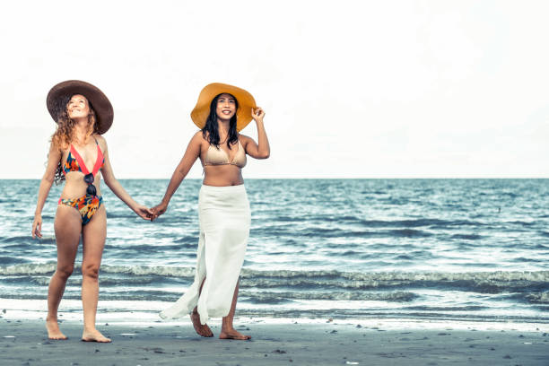 istock Happy women go sunbathing at sand beach in summer. 1029175656