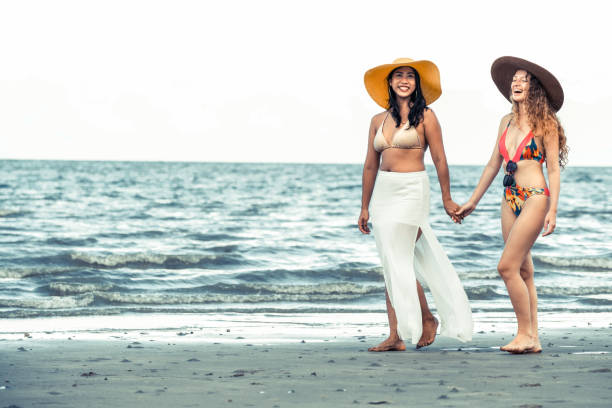 istock Happy women go sunbathing at sand beach in summer. 1029175706