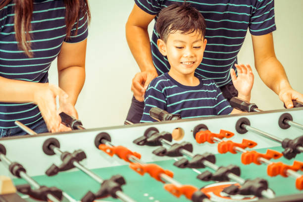 istock Happy kid playing foosball table with family. 1029175810