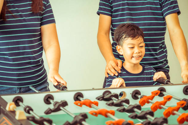 istock Happy kid playing foosball table with family. 1029175846