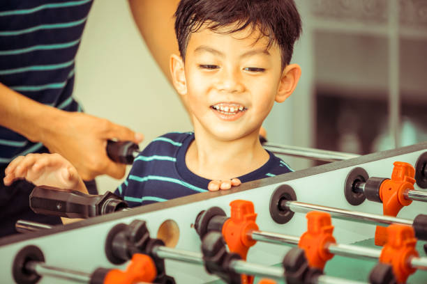 istock Happy kid playing foosball table with family. 1029175872