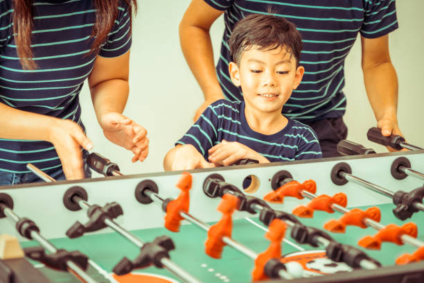istock Happy kid playing foosball table with family. 1029175890
