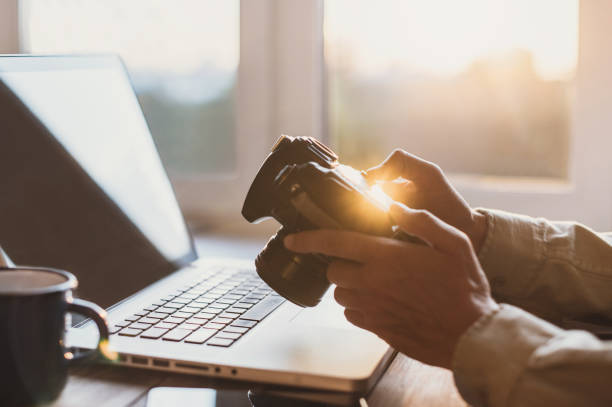 istock Photographer working with laptop and DSLR camera 1029176204