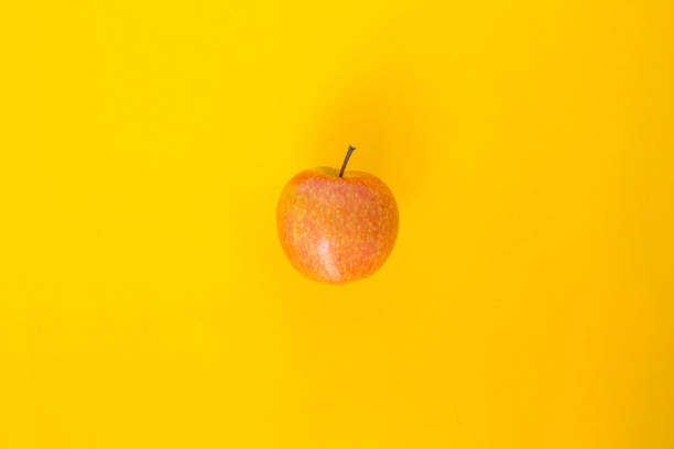 istock red apple top focus on yellow background 1029185566