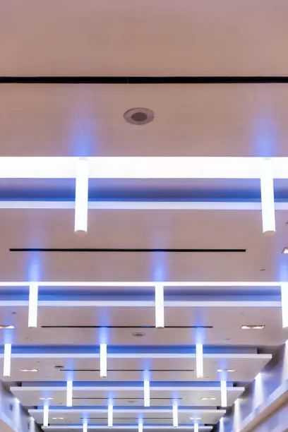 Vertical view on modern building, shopping mall, corporate office lights, lamps neon, LED blue lighting interior, inside, indoors