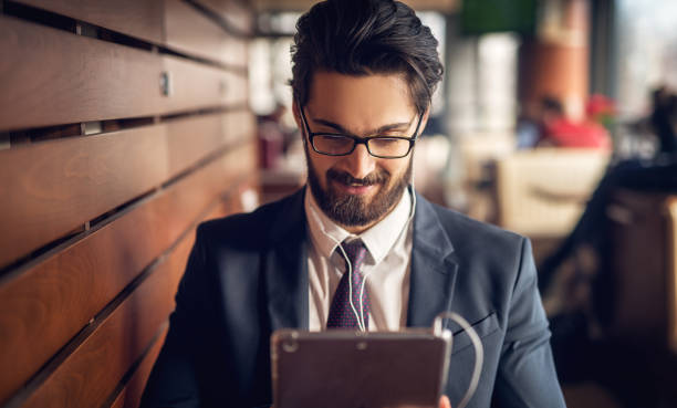 istock Young handsome modern businessman taking a break at coffee shop and using a tablet. 1029194866