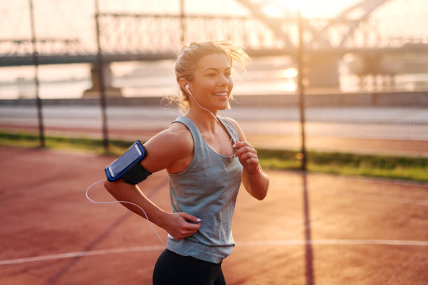 Beautiful sporty fit blond girl listening to the music and running early in the morning outside. Beautiful sporty fit blond girl listening to the music and running early in the morning outside. scoring run stock pictures, royalty-free photos & images