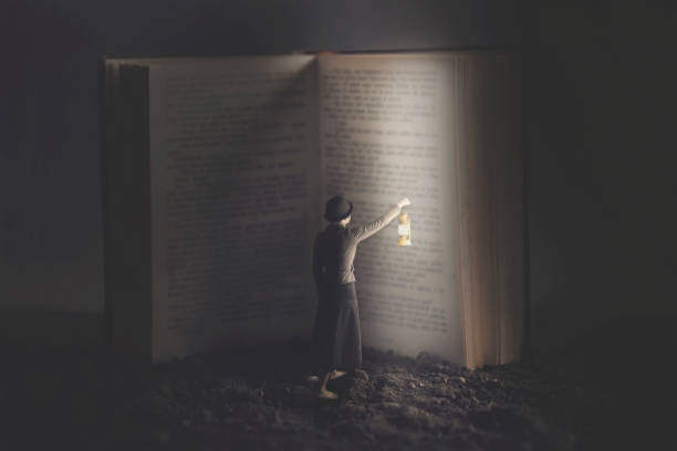 istock woman lights a gigantic book with a lantern at night 1029218324