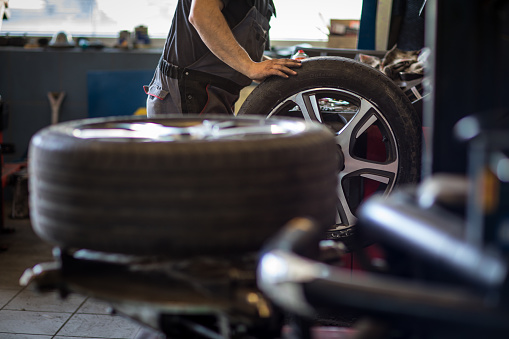 Equilibrio o reparación de la rueda y cambiar el neumático de coche en el garaje de auto servicio photo