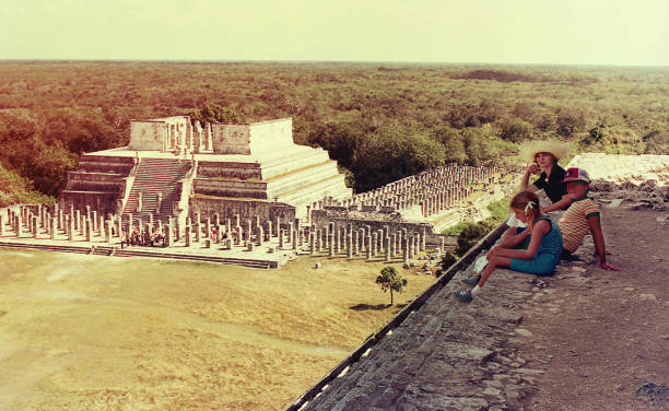 Vintage visit to Chichen Itza Vintage image of a family visiting Chichen Itza, Mexico, with the  Temple of the Warriors in the background. chichen itza photos stock pictures, royalty-free photos & images