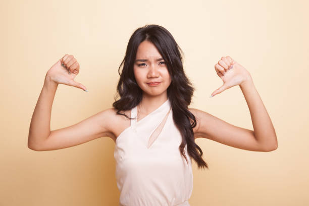istock Unhappy Asian girl show thumbs down with both hands. 1029227372