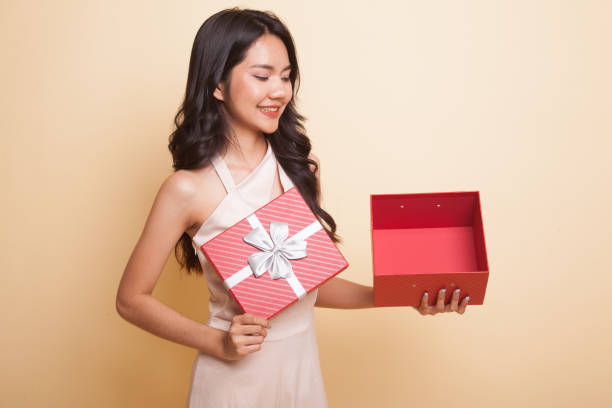 istock Young Asian woman open a golden gift box. 1029227648