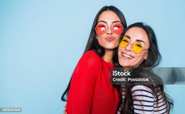 Foto de Amigos Para Sempre Dois Amigos De Adoráveis Fofos Menina Em Óculos De Sol Posando Com Sorriso No Fundo Azul e mais fotos de stock de Amizade