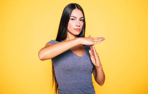 Time for break! Serious and confident beautiful woman in casual wear is doing T symbol or sign with help of her hands and looks on camera time out signal stock pictures, royalty-free photos & images