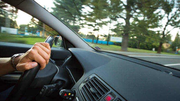 istock Man driving a car moving fast on a highway 1029236782