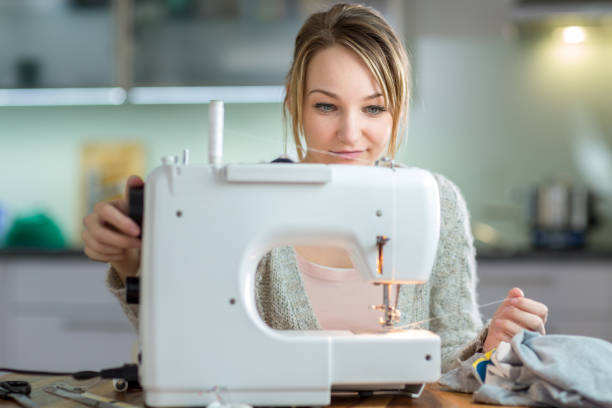 istock Pretty, young woman sewing clothes with sewing machine 1029239472