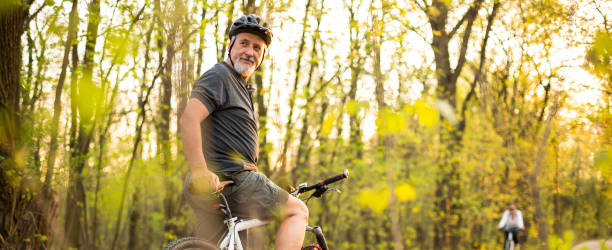 hombre senior en su bicicleta de montaña al aire libre - andar en bicicleta fotos fotografías e imágenes de stock